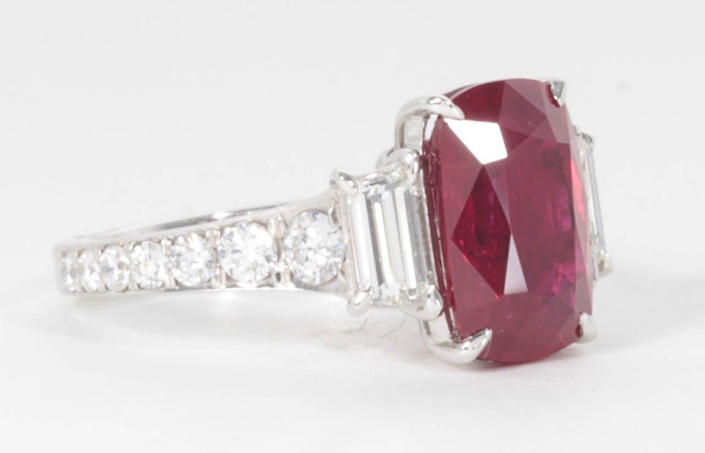 Certified natural 5.04 carat vivid cushion shaped ruby set in custom handmade diamond mounting. 1.24 carats of diamond sides stones and diamond band. All set in platinum.