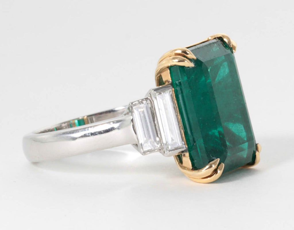 Large and impressive 9.60 carat emerald cut emerald set with 1.10 carats of fine white baguette cut diamonds. The emerald and diamonds are set in a custom, handmade platinum and 18k yellow gold mounting.