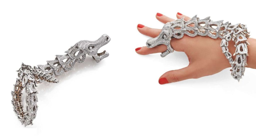 Amazing bracelet in white gold stylized in a Dragon, entirely articulated. 
fully set with approximately 50 carats of round cut diamonds. 
The wrist extends over the hand into the head, the articulated jaw forming the ring. 
Wrist size 17cm, ring
