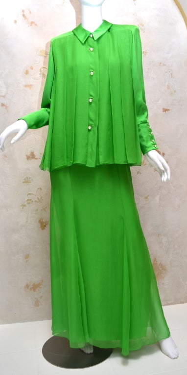 Gorgeous James Galanos evening ensemble. Kelly green chiffon blouse with a satin statement shoulder. Collar and sleeve are also in satin. Large pearl buttons down the front and at the sleeve cuffs. Matching skirt with layers of chiffon and side