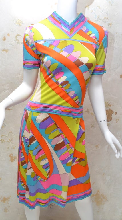 Vestido de punto de seda vintage de los años 70 de Emilio Pucci con un atrevido estampado geométrico. Bordes estampados en la manga, el cuello, la cintura caída y el bajo. Estampado multicolor con atrevidos tonos ácidos en limón, mandarina,