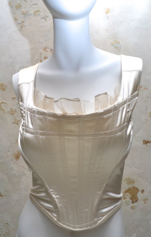 Vivienne Westwood boned bustier from the 1990's. Punk bridal. Creamy white satin stretch lycra and spandex. Zip back, boned front and back. Organza inset at neckline. Labeled UK size 12, more like a US 6-8. 

Very good condition