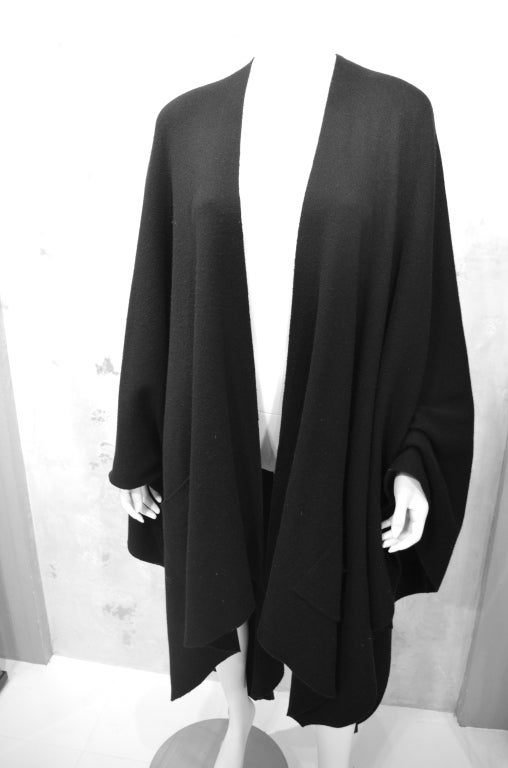 Chanel vintage 1990's unstructured wool knit black cape. One size. Minimal design, unlined. One patch pocket on front side. I lightened photos to show detail but cape is a true black with no fading or uneveness of color. Chanel label at neck in