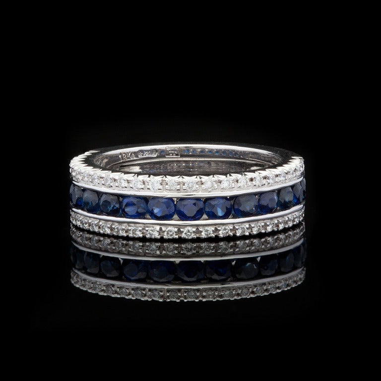 Favero 18Kt White Gold Band Ring features 15 Round Brilliant Cut Sapphires for a total approximate weight of 1.30cts accented by 50 Round Brilliant Cut Diamonds for approximately 0.26cts.  The ring weighs 8.06 grams and is a size 6.75.
