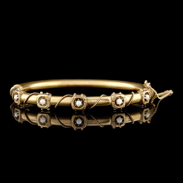 Vintage 14Kt Yellow Gold Bangle Bracelet featuring 5 Seed Pearls that measure 2.5mm in diameter.  The bracelet weighs 13.5 grams and measures 6.5