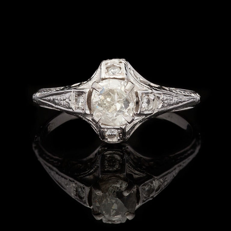 Antique Filigree Ring features 1 Old Mine Cut Diamond for approximately 0.72cts with L/M color and SI2 clarity, set in 14Kt White Gold, with an additional 4 Round Cut Diamonds for approximately 0.10cts. Ring is size 8 and weighs 2.4 grams.