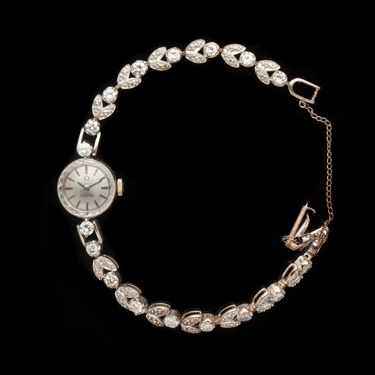 Omega lady's 14k white gold and diamond bracelet watch with 18 round cut diamonds for a total approximate weight of 1.54 cts and 13.9 grams. Watch head measures 14mm x 22mm and has a 6.75-inch bracelet.