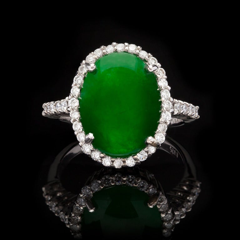 Estate 14Kt White Gold Oval Double Cabochon Cut Jade Ring set with 38 Round Brilliant Cut Diamonds for approximately 0.50ct. The total weight of the ring is 5.5 grams and is a size 7. Jade is natural with no indications of impregnation and GIA
