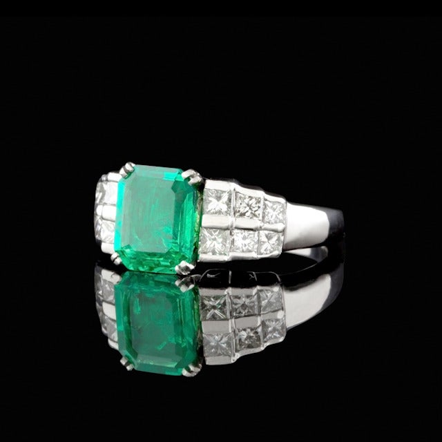 Platinum Ring features an Emerald Cut Emerald for approximately 2.45cts set with 12 Princess Cut Diamonds for a total approximate weight of 1.60cts.  Total weight of ring is 14.1 grams and is a size 8.