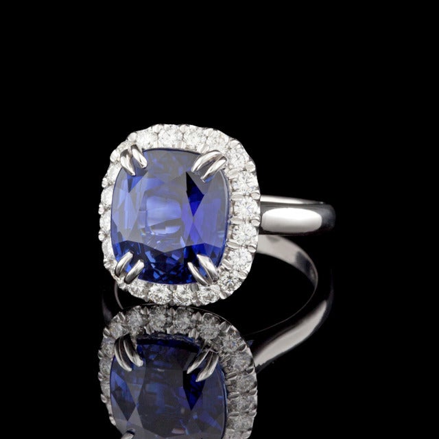 Platinum ring setting features one Rectangular Cushion Cut Natural Blue Sapphire for a total weight of 7.06cts accented by approximately 0.59cts of Round Brilliant Cut Diamonds. The total weight of the ring is 9.8 grams. Sapphire has not been heated