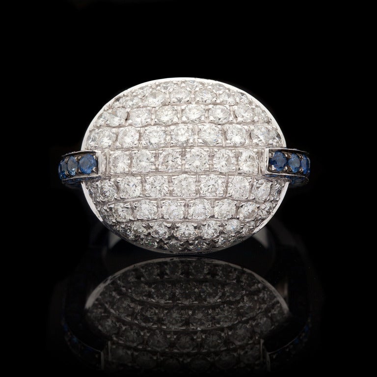 Favero 18Kt White Gold Cocktail Ring features 2.23cts of Round Brilliant Cut Diamonds accented by 84 Round Brilliant Cut Blue Sapphires for approximately 1.57cts.  The total weight of the ring is 10.7 grams, the face of the ring measures 17mm x 25mm