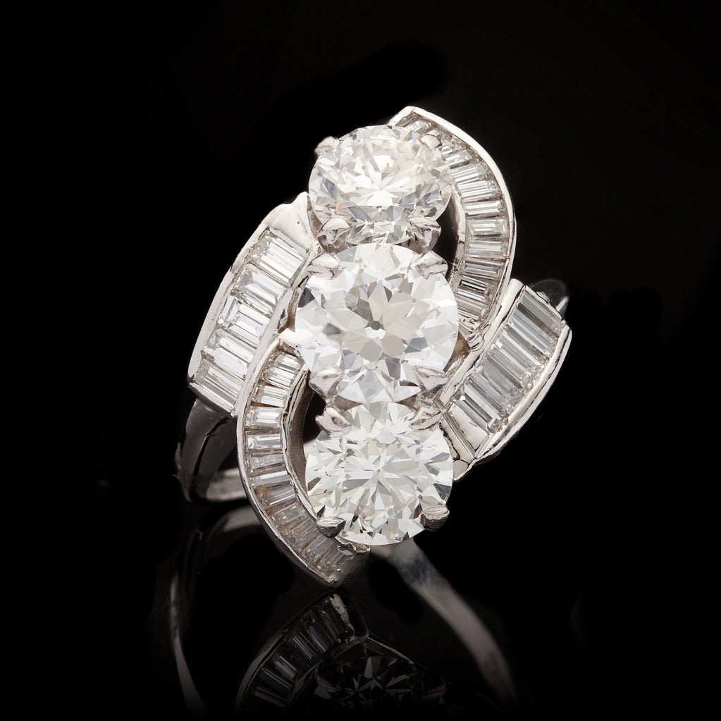 Platinum Estate Cocktail Ring features 3 Old Mine Cut Diamonds for approximately 3.40cts with H/I, VS1/2 color and clarity accented by 34 Baguette Cut diamonds for an additional 1.20cts.  Ring weighs 8.76 grams and is a size 7.5.