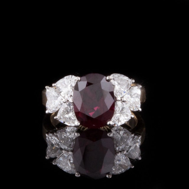 Ring features one 3.08ct Oval Ruby with 6 Heart cut Diamonds with a total approximate  weight of 1.50cts in a 14kt yellow & white gold setting.  The total weight of the ring is  5.4 grams and is a size 5.5.  Ruby is heated and AGL report #CS80635 is