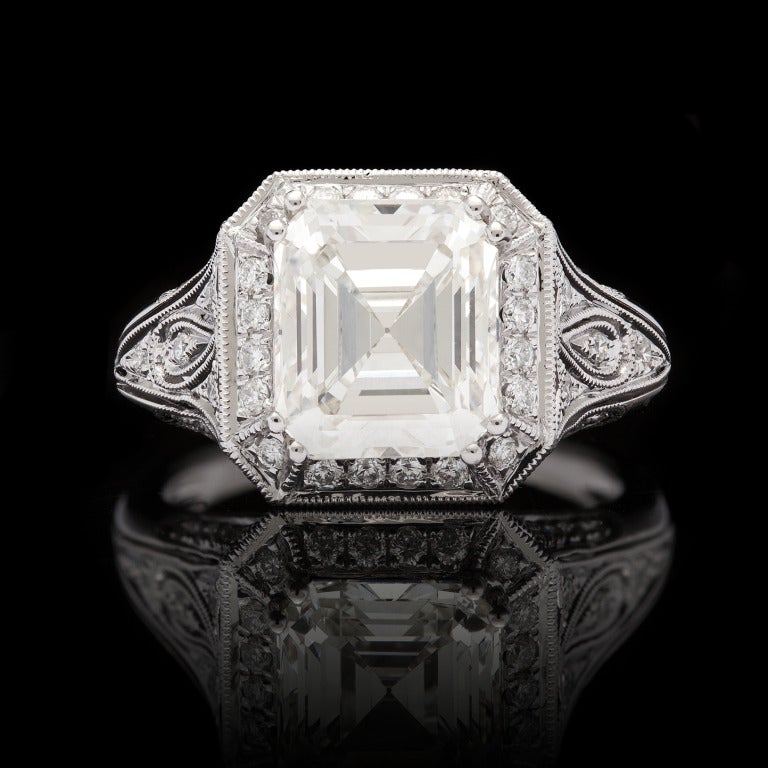 GIA emerald cut diamond measures 9.52 x 8.31mm, making it an almost square shape cut.  It is J color, VS1 clarity and weighs 3.68 carats.  The main stone is set in 18k white gold accented with 60 round cut diamonds at 0.56cts with a total