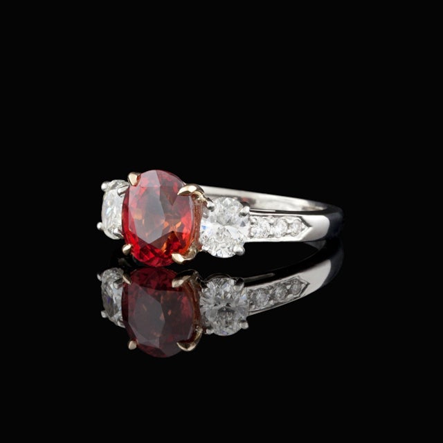 Custom ring features one 2.81ct Oval Cut Red-Orange Sapphire set in 18Kt Yellow Gold with 8 side Diamonds with a total approximate weight of 0.78cts in a platinum setting.  The total weight of the ring is 6.1 grams.  Sapphire is natural and is not