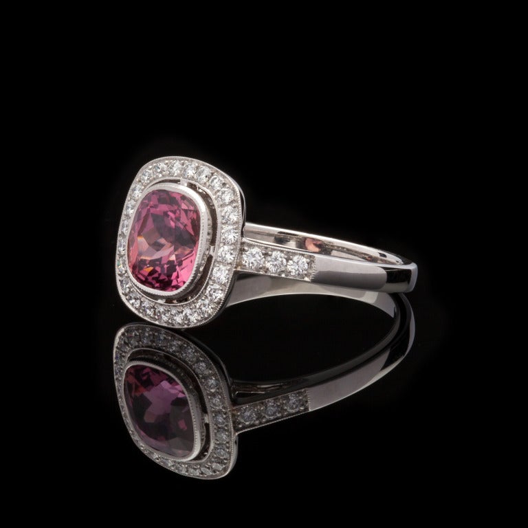 Cette bague personnalisée présente un saphir coussin de 1::98 ct de couleur naturelle Padparadscha et 30 diamants ronds d'un poids total approximatif de 0::28 ct dans une monture en platine.  Le poids total de la bague est de 4::8 grammes.  Le