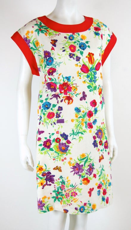 Here's a vintage linen dress featuring an exuberant floral print with butterflies and Gucci logo interspersed. This sleeveless dress closes with 3 buttons up the back. It is split on each side up to the top of the hips. Fully lined.
