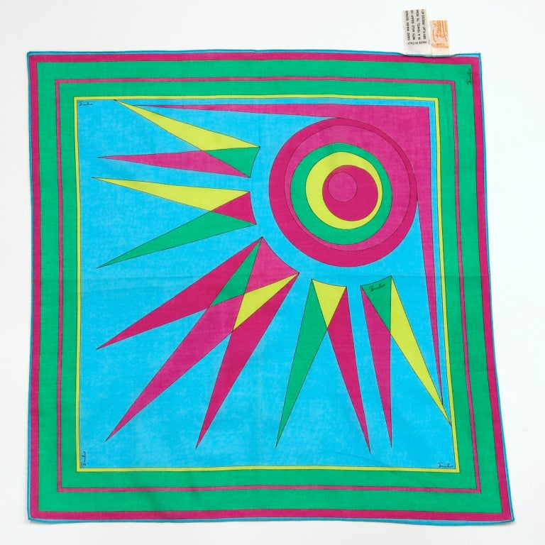 Emilio Pucci is one of history's most memorable designers. His name is synonymous with geometric prints in a kaleidoscope of colors.

Here's a square cotton scarf featuring a sunburst print in magenta, blue, green and yellow. Machine-finished