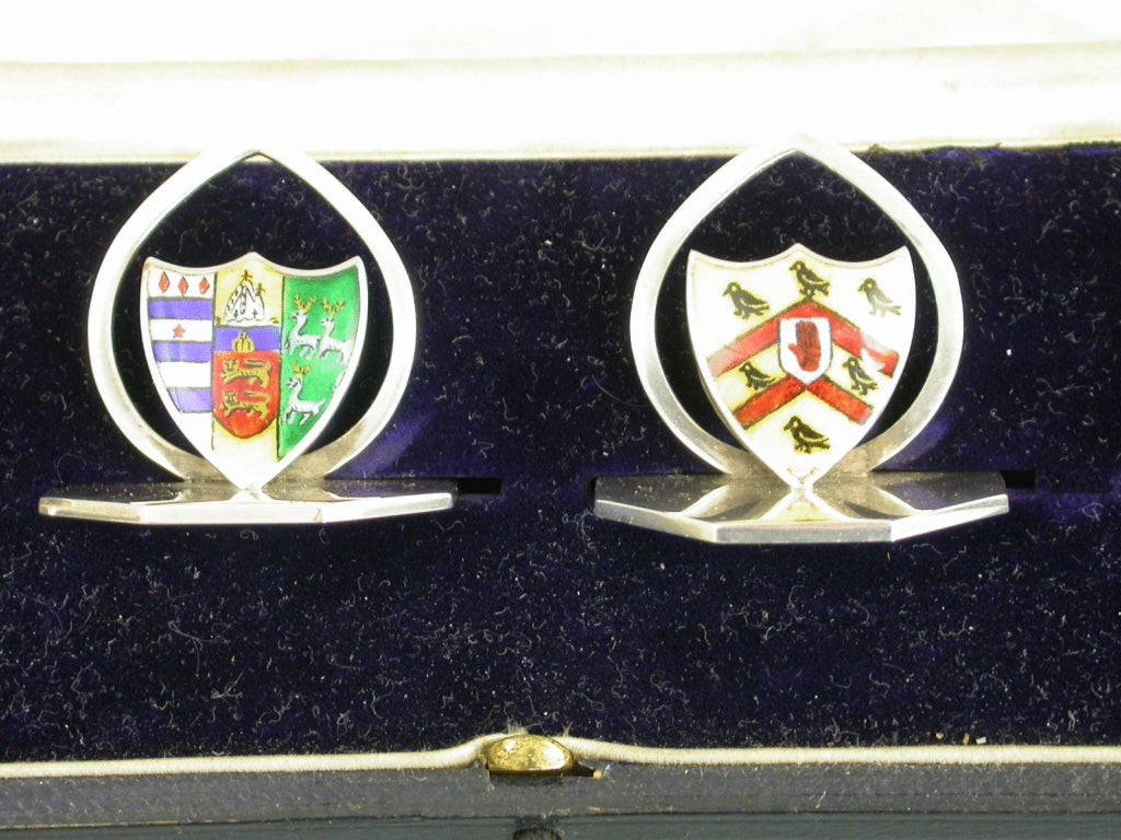 A fine set of four Edwardian cased silver and enamel Menu Holders, the shield shaped stands on octagonal bases, enamelled with the Coats of Arms of Worcester and Lincoln Colleges, Oxford University. Complete with original silk and velvet lined
