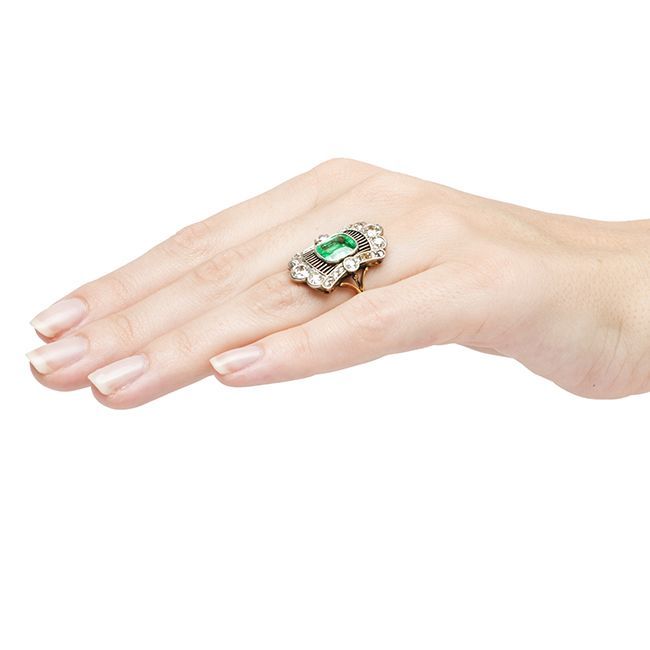 Montgomery is an intricately designed platinum and 18k yellow gold Edwardian era navette ring featuring a spectacular bezel set cushion shaped natural Colombian emerald.  This spectacular center stone is certified by Guild Laboratories and measures