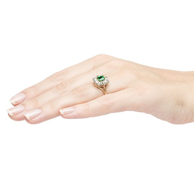 Hyde Park is a classic Victorian emerald and diamond cluster ring made from platinum and 14k yellow gold featuring a 0.63ct square step cut natural emerald accompanied by a Guild Laboratory certificate stating the emerald has color and inclusions