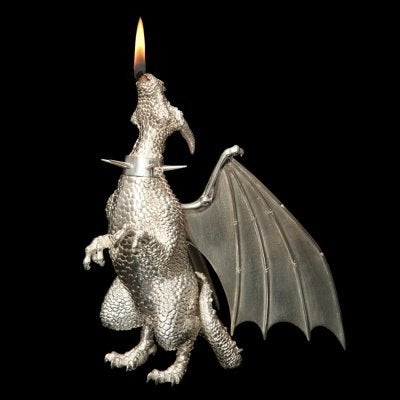 What better creature to breathe fire than this friendly little Dragon? Actually, he is quite a heavy little Dragon, cast in solid silver and finely chased by hand in intricate detail.
 The wick disappears down his throat into his belly to the fuel