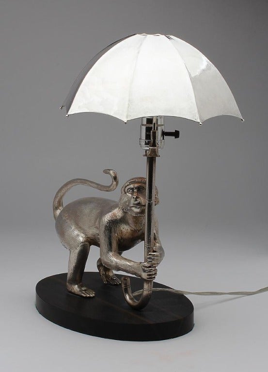 This is one spectacular table lamp! Over 120 ounces of cast silver, finely chased by hand. The electric light reflects softly under the solid silver umbrella shade.
 Sited on an ebony base, wired up and ready to switch on.

 Other CRAWFORD Monkey