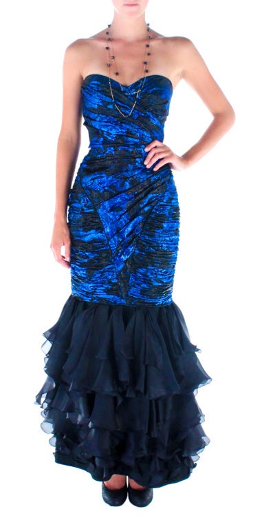 Beautiful Ungaro mermaid gown in black and cobalt silk lamé. 
Inspired by the finest 1950's French tradition, it has a fully boned corset and layers of bias cut ruffles to the floor. Size: SMALL
Bust: 32