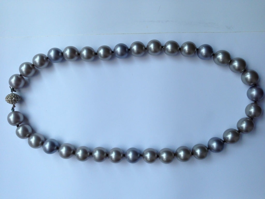 Magnificent 1980s Kenneth Jay Lane deep grey charcoal faux pearl necklace with a pave set jeweled clasp.  Pearls are heavy and luminous.  Length 30.5
