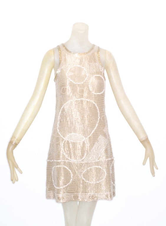 This is an extremely rare and finely beaded silver metal thread fabric Mila Schon dress from the 1970s.  Mini dress is beaded in a mod geometric motif with glass beads and clear bugle beads.  Champagne color.

Mila Schon will soon be celebrated in