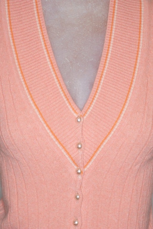 Classic with a twist: a Chanel cashmere tennis sweater vest in a sorbet color with pearl buttons.  Each button has Chanel written across it in tiny letters.

