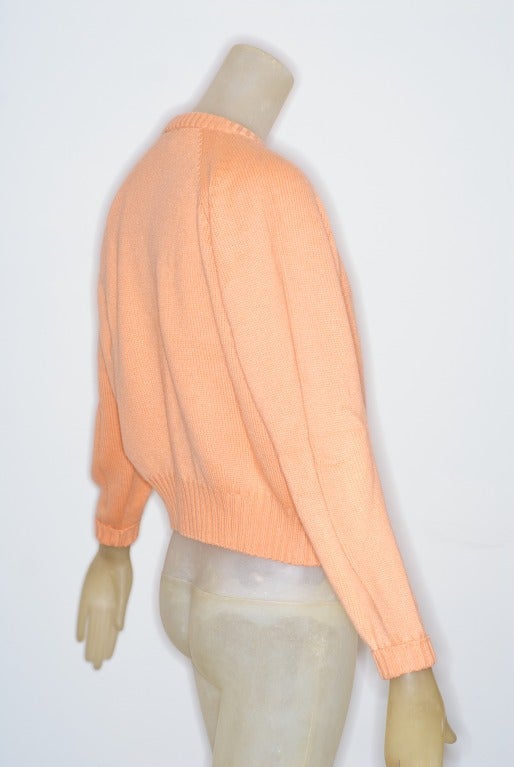 A super soft 1990s Gianni Versace cashmere twin set a peach sherbet color with Medusa buttons.

size 4