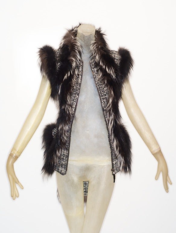 A fiercely beautiful and romantic Sarah Burton Fall 2011 fox fur tweed vest with zipper detail and patent tabs.  Fox fur lined hem and shoulder seams.  Pristine.  

Will fit a size 2/4 or a small 6.