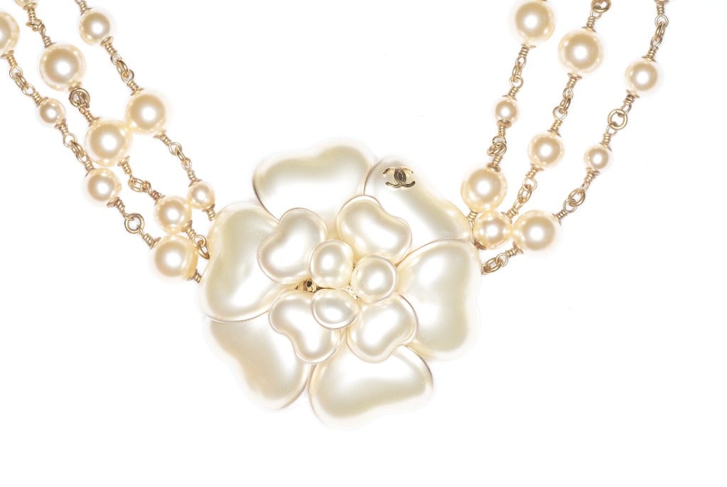 A beautiful Chanel camellia and triple strand necklace.  Signed.

Camellia is 2 1/4