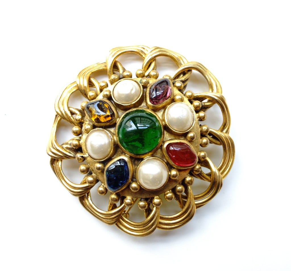 Chanel brooch with amethyst, ruby and sapphire colored stones and faux pearls set in gold.  Signed Chanel.  Made in France.
