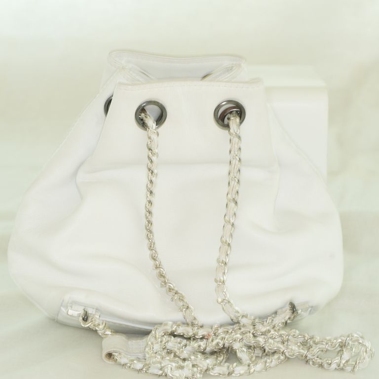 The classic Chanel lambskin bag turns into an irresistible backpack in crisp white with leather interlaced chain straps.  Large CC detail stitched on the bag. Perfect for journeys near and far!  In excellent condition too!