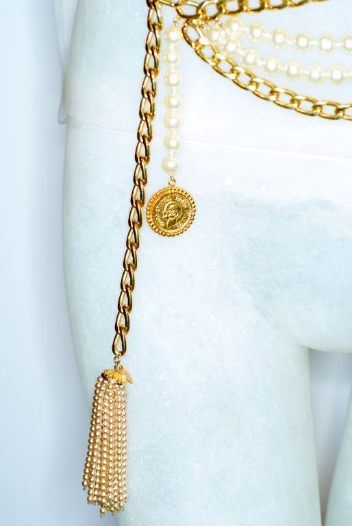 A classic Chanel belt with two strands of pearls and micro pearl tassel..  There is also a dangling medallion of Mademoiselle Coco Chanel.  Pristine condition.  Stamped Chanel.
