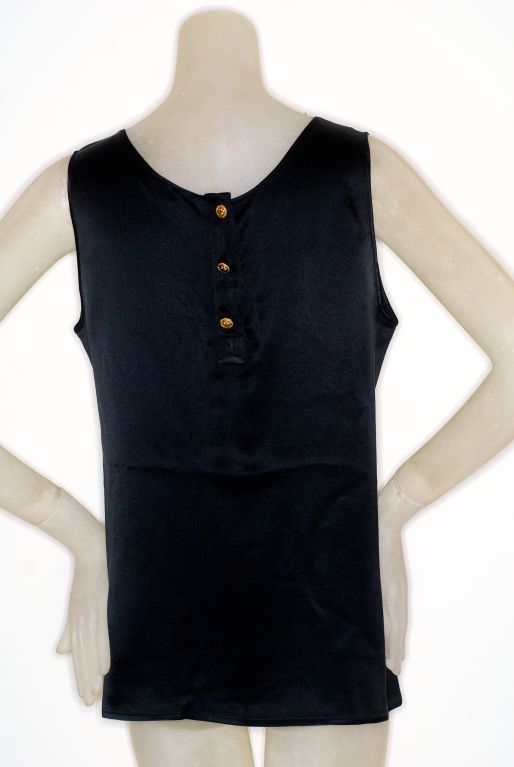 Chanel black silk tank with three four leaf clover gilt buttons on the back.  Loose fit.  Excellent condition.

Measurements:
Total length: 25