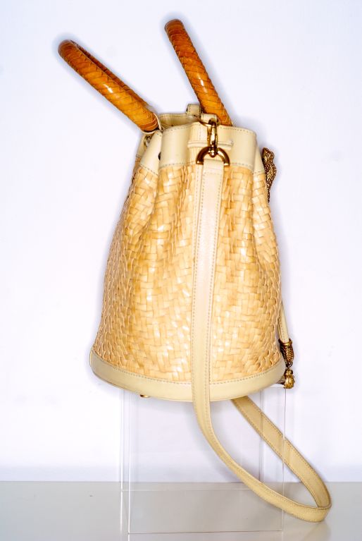 This is the ultimate summer bag by Barry Kieselstein-Cord.  A super soft butterscotch colored woven leather bucket bag has drawstring with matte gold frog and ladybug charms.  Please note that the handles are not discolored as they appear to be in