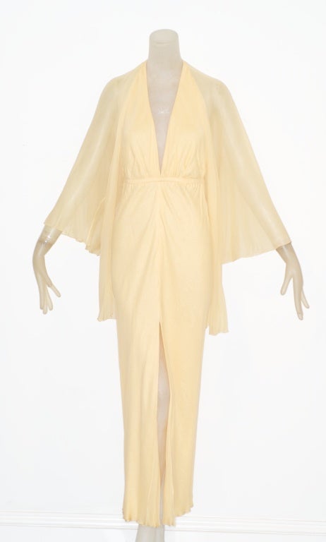 Beautiful pale buttercup yellow Halston gown from the 1970s.  Layers of chiffon.  Plunging halter neck and bare back. Comes with its original chiffon cardigan and chiffon belt.<br />
<br />
RARE vintage<br />
STORE HOURS: Monday to Friday 11:30