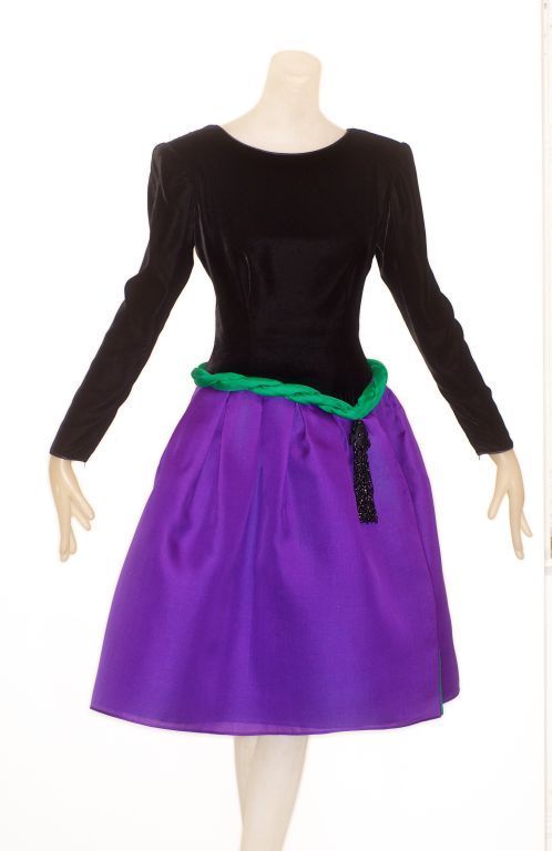 1980s Valentino Couture cocktail dress with a black silk velvet bodice and a slightly dropped waist.  The full skirt is in three panels of silk gazar in shades of amethyst, emerald and black.  Padded coiled self belt detail and large beaded