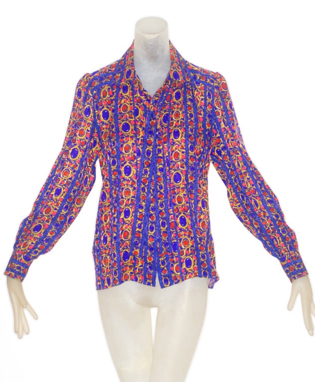 From the master of the silk blouse, is this jewel print silk Yves Saint Laurent rive gauche blouse in amethyst and red with scarf ties.  Blouse buttons down the front.