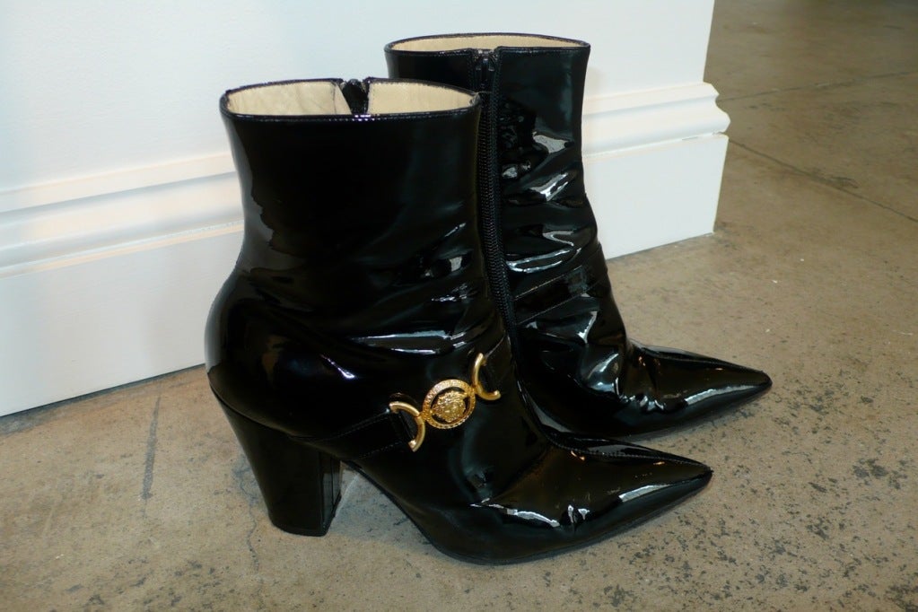 Early 1990s Gianni Versace black patent leather booties with gold Medusa medallion.  These are from the famed period when Gianni Versace was using gold safety pins on his glamourized version of punk inspired clothing.  Size 38.

RARE