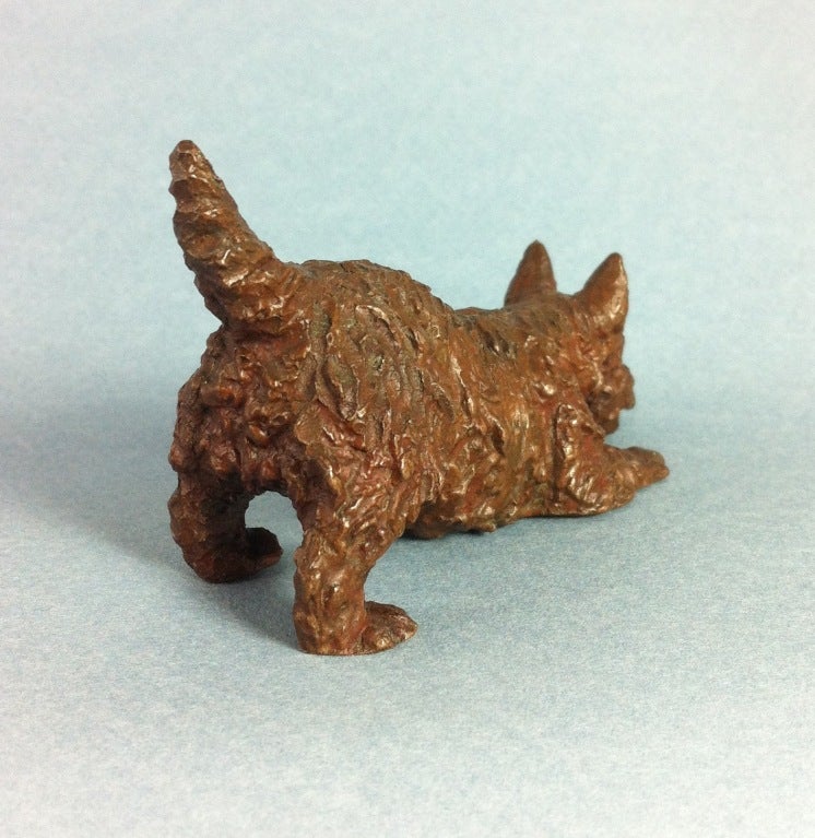 Bronze Scottish Terrier with reddish-brown patina.
One of a series of small dog bronzes made by the Gorham & Co. Foundry. One of 30. 
Stamped Gorham & Co. ?© M Kirmse?.
These rare little bronze dogs were commissioned by Gorham & Co in the 1930?s
