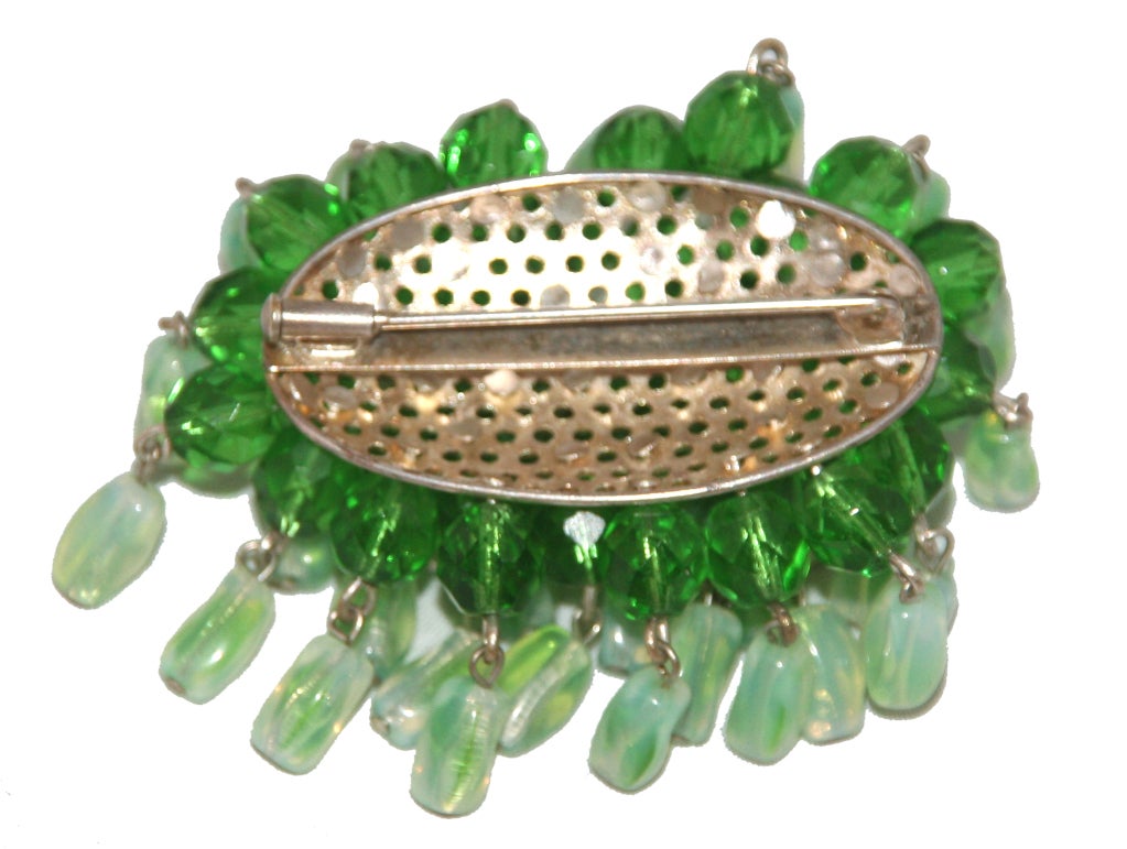French haute Couture Brooch, in the shape of a pompom made of green faceted crystal beads and dangling light green poured glass/gripoix beads. Silver plated metal, French clasp. 
Excellent condition, 
size: 6 x 5 cm - 2 1/3 x 2 in. 