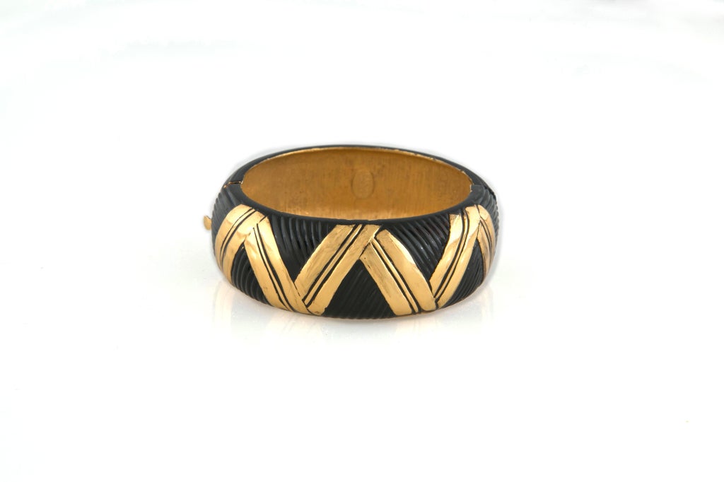 VINTAGE LANVIN SIGNED GOLD AND BLACK ENAMEL BRACELET CUFF. This bold enameled and embossed chevron pattern piece is as simple as it is dramatic. Deep black enameling gives way to the golden chevrons from its base metal. Weighty as you'd expect of