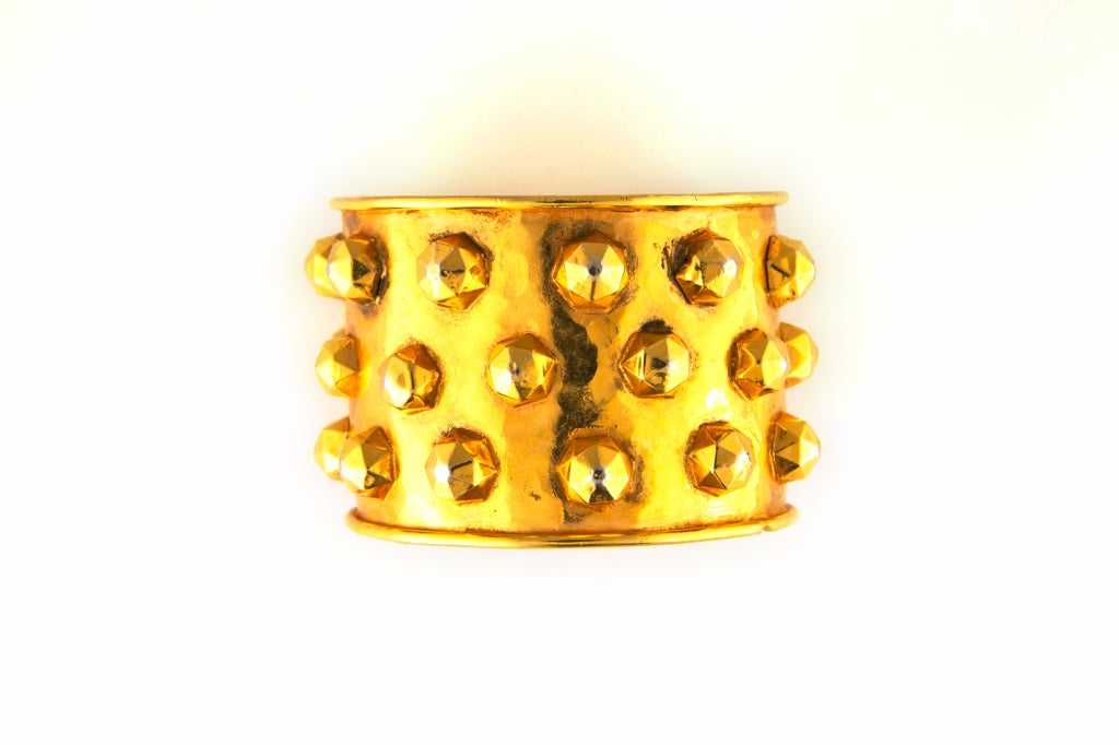 Exceptional and rare DOMINIQUE AURIENTIS gold vermeil bracelet cuff.  Wide cuff design with simulated nail head studs all in 18k gold vermeil.  Smooth, faceted stud surfaces are placed both randomly and symmetrically.  Comfortable opening to slip