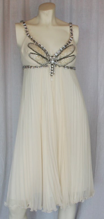 Emerald cut stones on straps and around top. White stones and clear beads in large butterfly motif with empire waist. Beautiful pleats in ivory silk with silk lining.