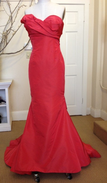 There are no words to describe this Oscar de la Renta strapless mermaid gown, but we will do our best.It is a bright beautiful coral that looks great on everyone. From the sculptural bust to the fitted bodice and the dramatic mermaid train that