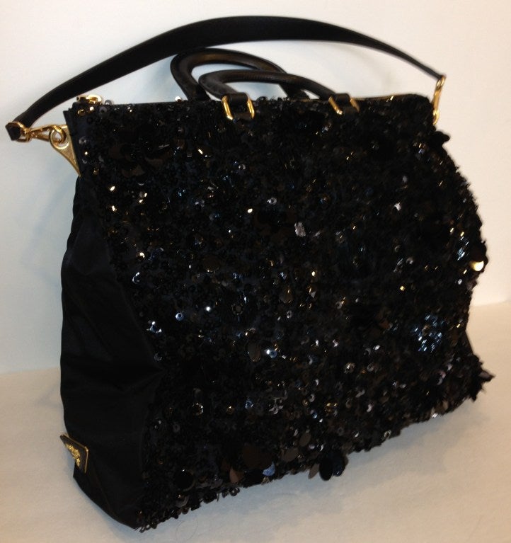 This is an authentic PRADA Tessuto & Ricamo Sequin Tote in Black. This stylish tote is crafted of black nylon with a full frontal sequined design. The bag features rolled leather top handles, a looping leather shoulder strap, a rear zipper pocket